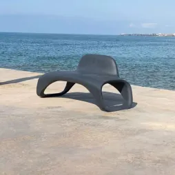 Banc urbain design monobloc en plastique gris sur une plage Banc urbain design monobloc en plastique gris sur une plage