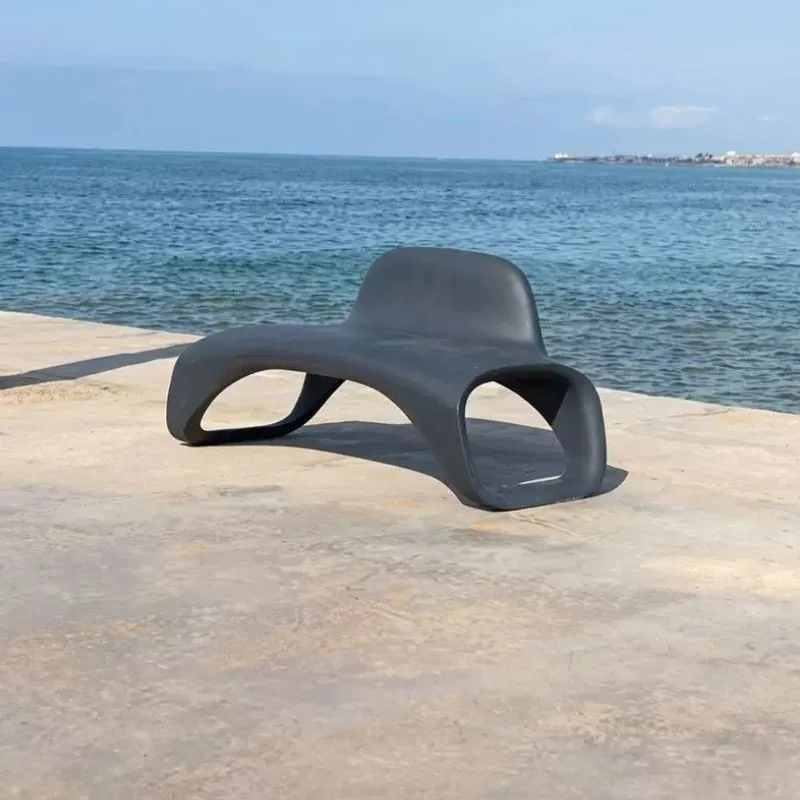 Banc urbain design monobloc en plastique gris sur une plage Banc urbain design monobloc en plastique gris sur une plage