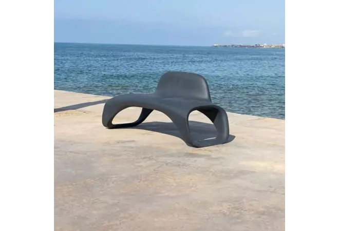 Banc urbain design monobloc en plastique gris sur une plage Banc urbain design monobloc en plastique gris sur une plage