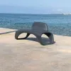 Banc urbain design monobloc en plastique gris sur une plage Banc urbain design monobloc en plastique gris sur une plage